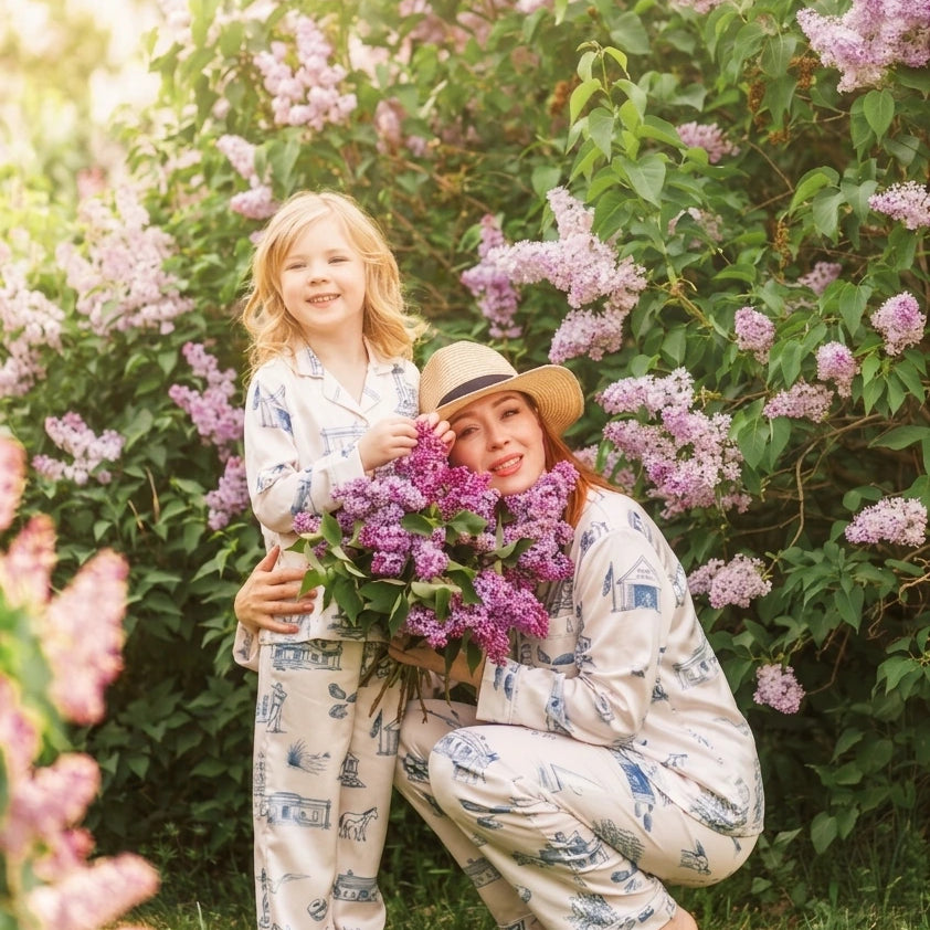 Woman and child in matching outfits surrounded by lilac bushes