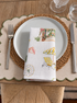 Folded Palm Beach linen dinner napkin featuring colorful coastal Florida illustrations