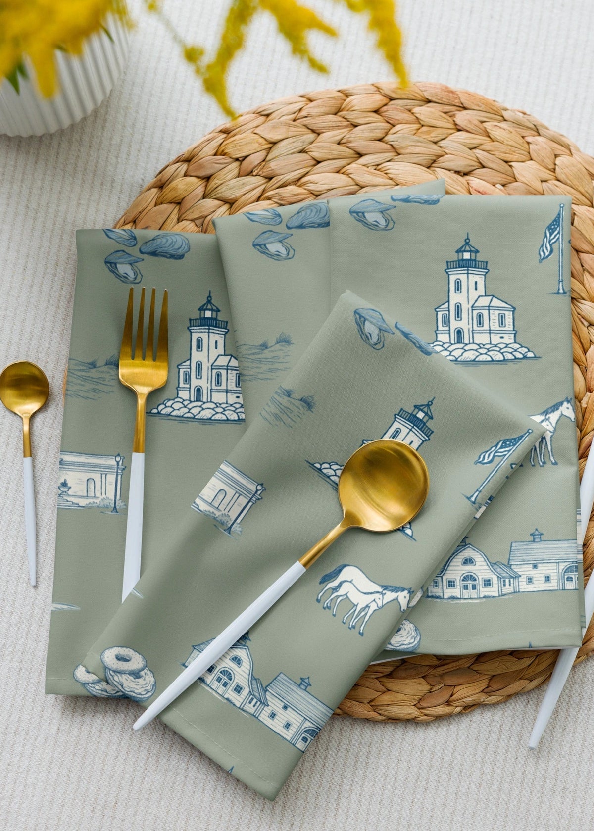 oyster and arrow Napkins with lighthouse toile design on a woven placemat with cutlery