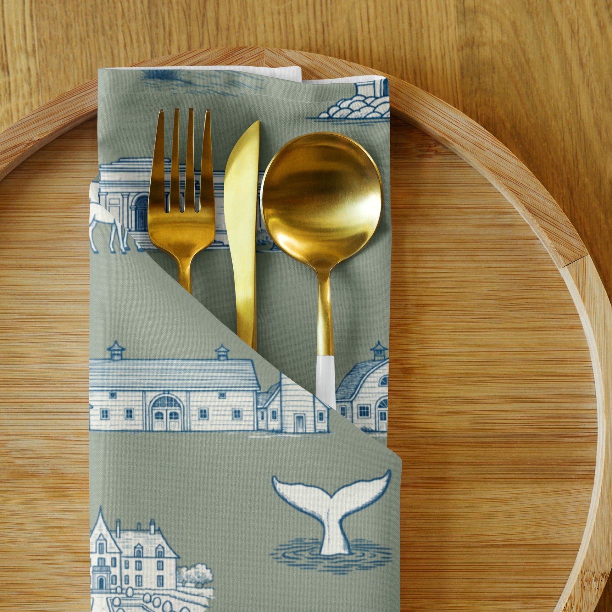 Folded napkin with gold cutlery on a wooden surface