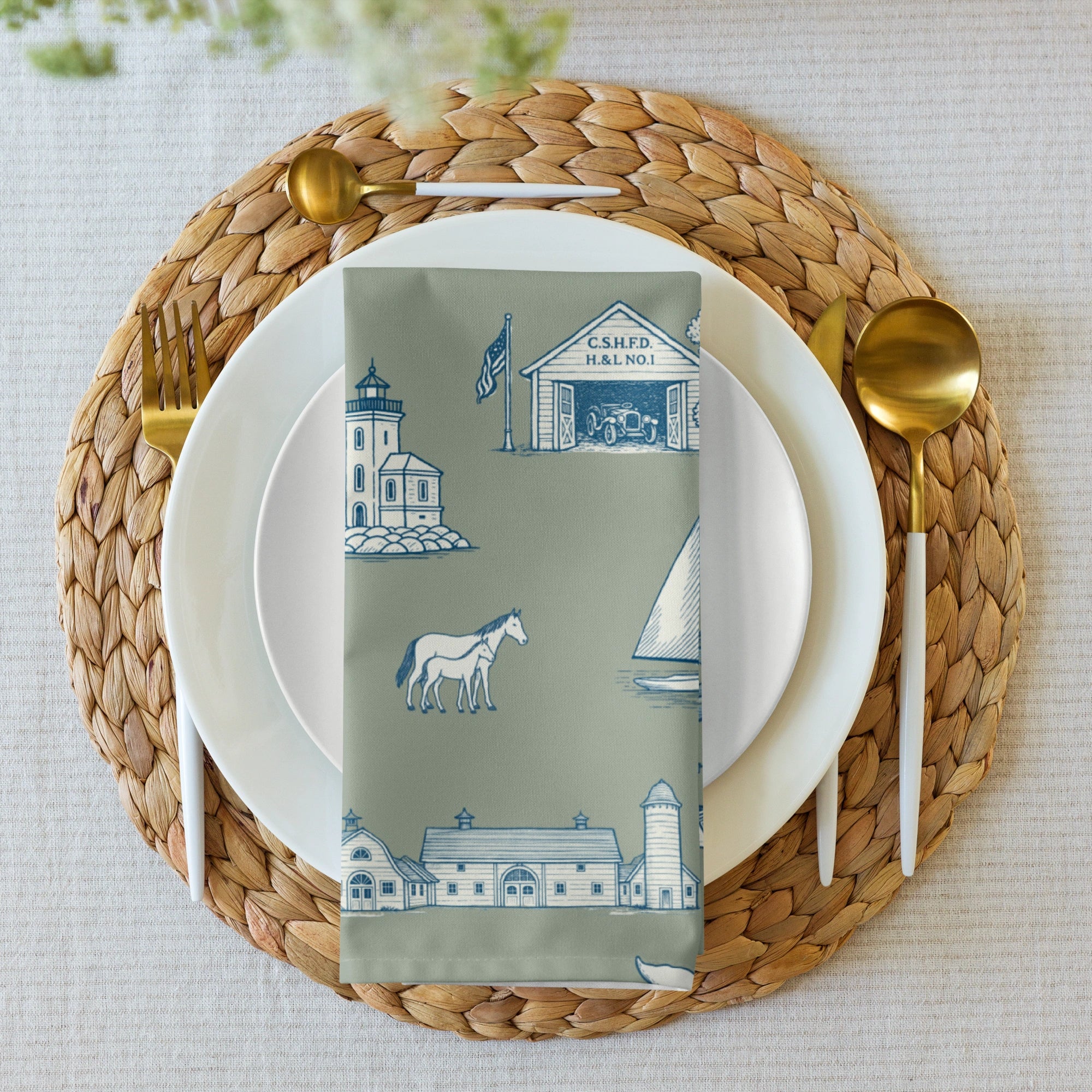 Place setting with woven placemat, white plates, gold cutlery, and a patterned napkin.