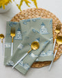 Napkins with lighthouse design on a woven placemat with cutlery