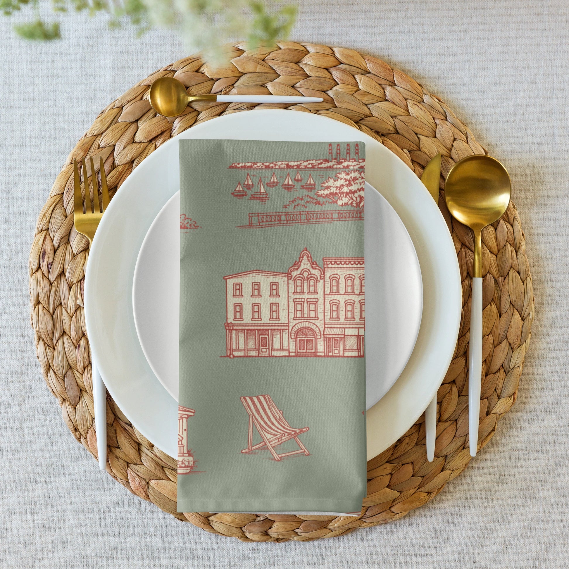 Dining table setting with a woven placemat, white plates, gold cutlery, and a decorative napkin.