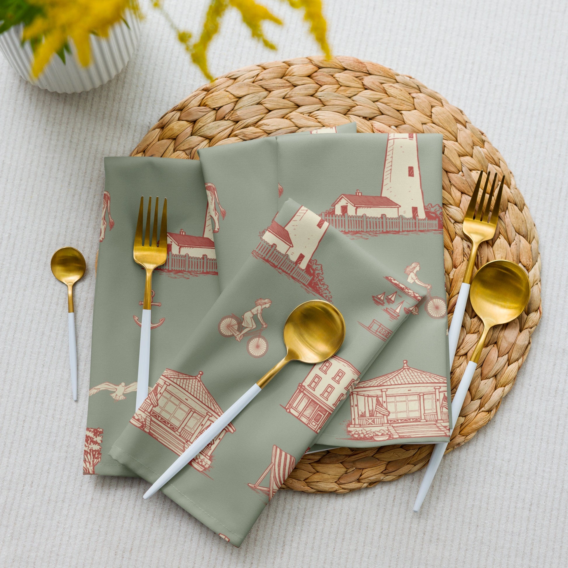 Set of green napkins with red pattern on a woven placemat with cutlery.