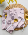 Set of patterned napkins on a woven placemat with cutlery