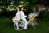two girls sitting on a bicycle in the northeast with a pink house behind them wearing matching costal toile print bamboo pajamas from oyster and arrow