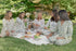 five woman sitting on a picnic blanket in north east all wearing organic bamboo toile two piece pajamas from oyster and arrow